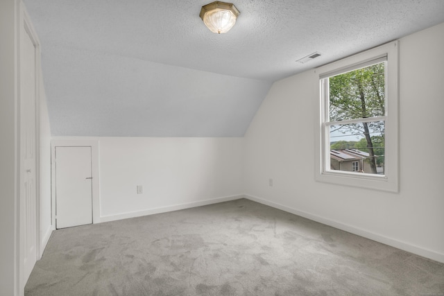 9 Florence St, East Haven, CT 06513 - additional living space featuring carpet flooring, a textured ceiling, vaulted ceiling, and baseboards