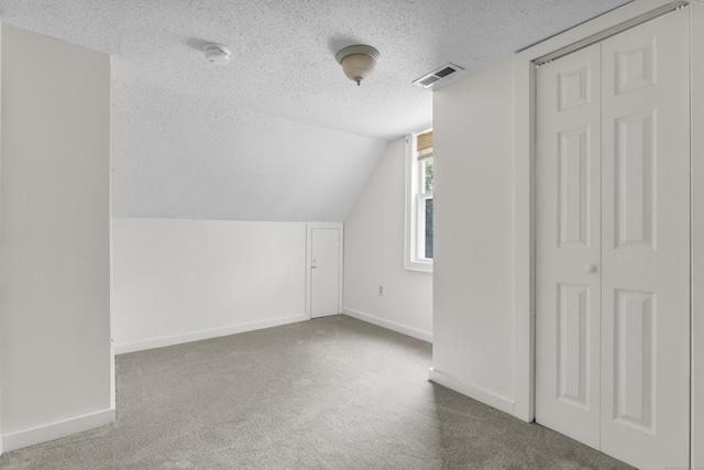 9 Florence St, East Haven, CT 06513 - additional living space with a textured ceiling, carpet, baseboards, and lofted ceiling