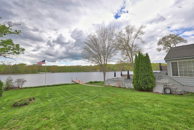 view of green lawn featuring a water view and stairway