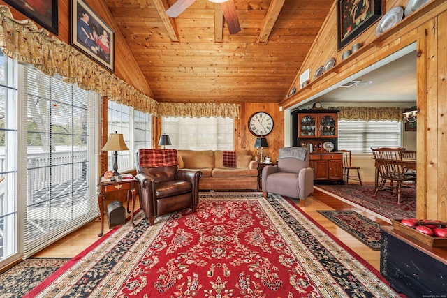 living area with wood ceiling, wood finished floors, wooden walls, a ceiling fan, and high vaulted ceiling
