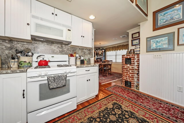 kitchen with white appliances, light wood-style floors, white cabinetry, backsplash, and a wainscoted wall