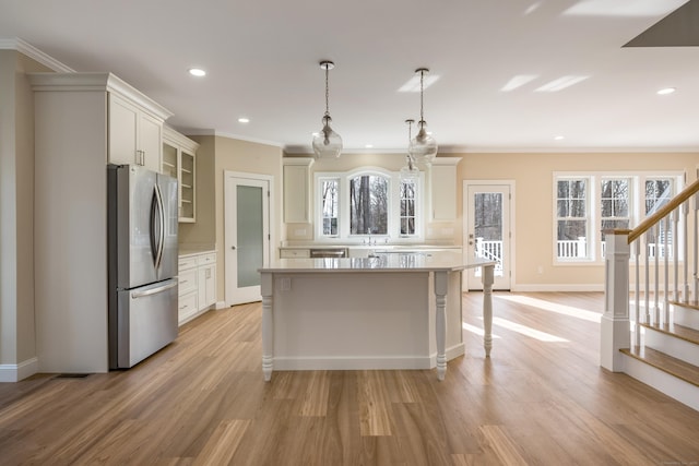 40 Allyn St, Groton, CT 06355 - kitchen featuring appliances with stainless steel finishes, light wood-style flooring, light countertops, a center island, and glass insert cabinets