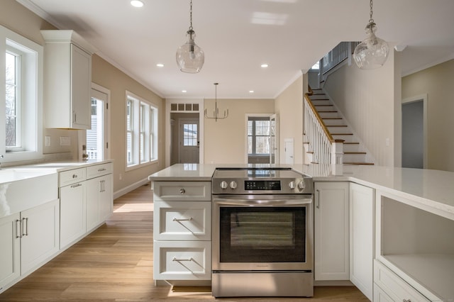 40 Allyn St, Groton, CT 06355 - kitchen featuring electric range, light wood-style flooring, light countertops, crown molding, and hanging light fixtures