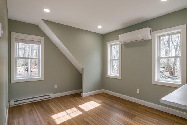 40 Allyn St, Groton, CT 06355 - additional living space with baseboard heating, a wall unit AC, light wood-type flooring, baseboards, and recessed lighting