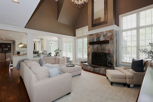 110 Nursery Rd, Ridgefield, CT 06877 - living area with decorative columns, wood finished floors, healthy amount of natural light, a stone fireplace, and high vaulted ceiling