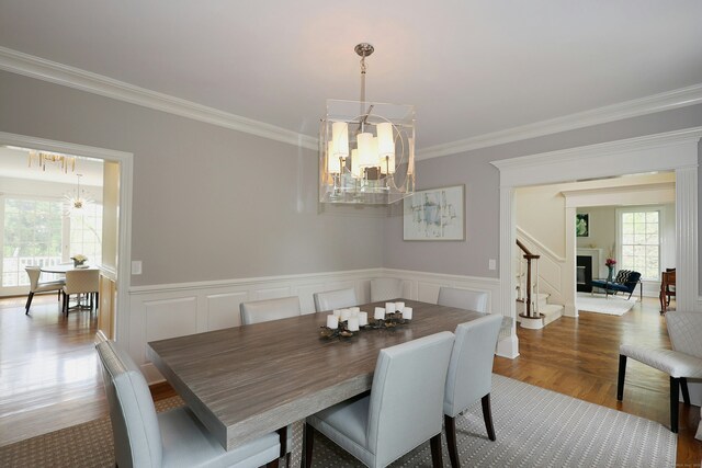 110 Nursery Rd, Ridgefield, CT 06877 - dining room featuring a chandelier, ornamental molding, stairway, wainscoting, and a decorative wall