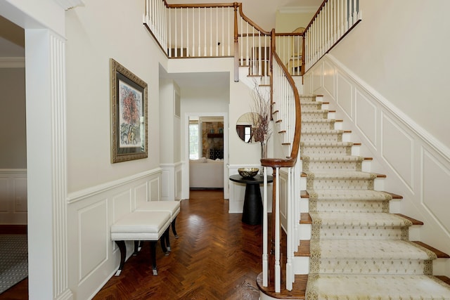 110 Nursery Rd, Ridgefield, CT 06877 - stairway featuring wainscoting, a decorative wall, and a high ceiling