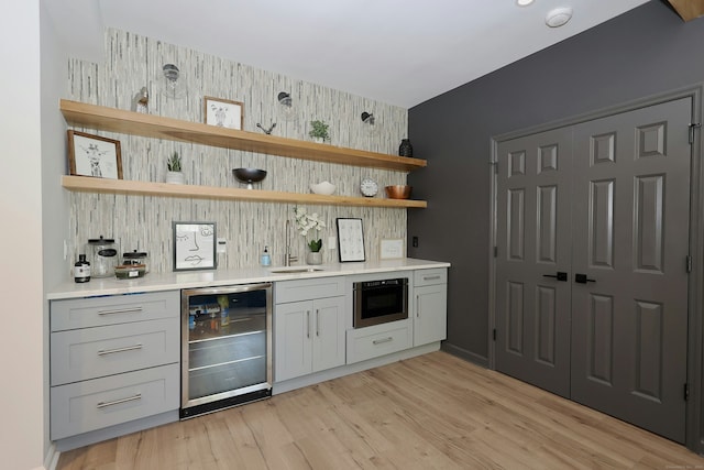 110 Nursery Rd, Ridgefield, CT 06877 - indoor bar featuring wine cooler, an accent wall, light wood-style floors, tasteful backsplash, and wallpapered walls