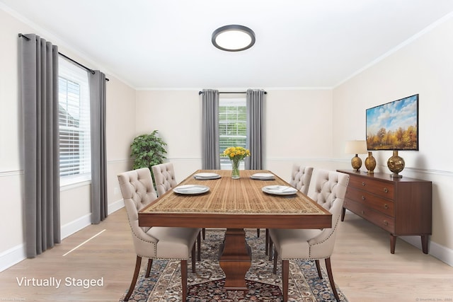 dining area featuring light wood finished floors, baseboards, and crown molding