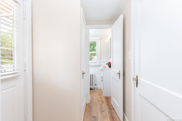 hall featuring radiator heating unit and light wood-style floors