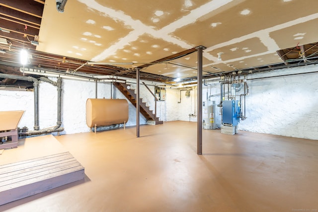 unfinished below grade area with heating fuel, water heater, and stairs