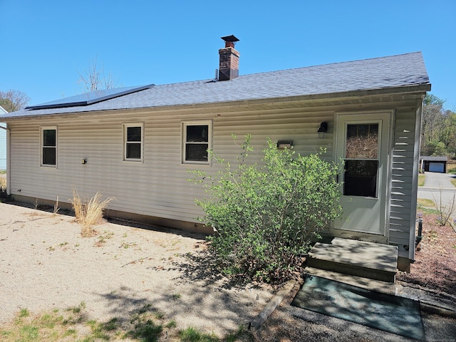 30 Huntley Rd, Killingly, CT 06241 - back of property featuring solar panels, a shingled roof, and a chimney
