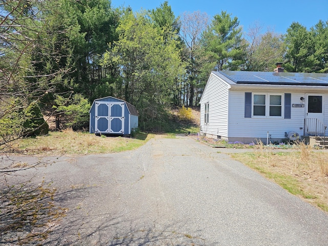 30 Huntley Rd, Killingly, CT 06241 - view of side of home featuring a storage shed, an outdoor structure, and a chimney
