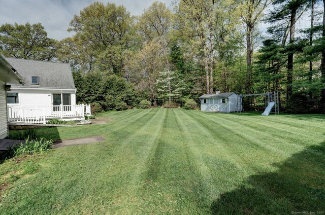 39 Eastgate Ln, Enfield, CT 06082 - view of grassy yard with a storage unit, an outdoor structure, and a wooden deck