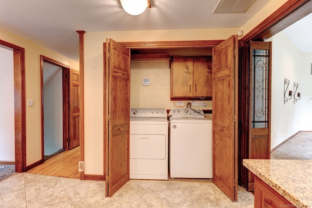 39 Eastgate Ln, Enfield, CT 06082 - laundry area with washing machine and dryer, cabinet space, baseboards, and a textured ceiling