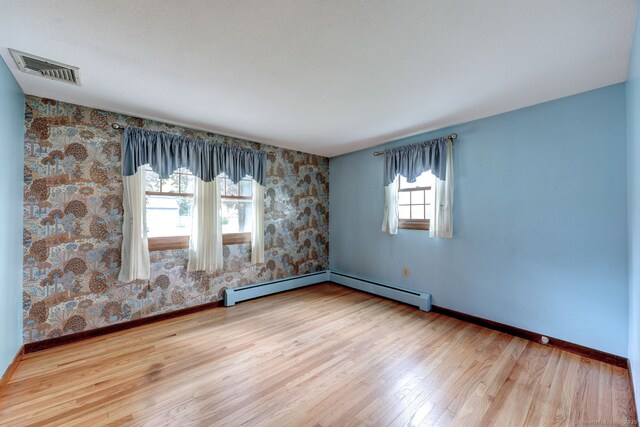39 Eastgate Ln, Enfield, CT 06082 - spare room with wallpapered walls, baseboards, wood finished floors, and baseboard heating