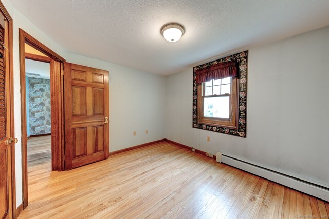 39 Eastgate Ln, Enfield, CT 06082 - empty room with a baseboard radiator, light wood-style flooring, baseboards, and a textured ceiling