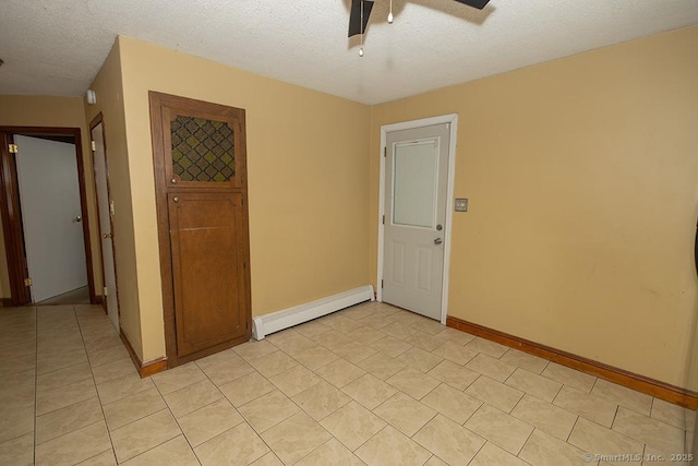 unfurnished room with a baseboard radiator, ceiling fan, baseboards, light tile patterned floors, and a textured ceiling