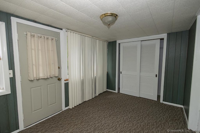 unfurnished bedroom with carpet floors, a closet, and baseboards