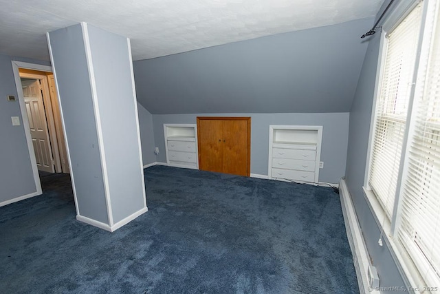 additional living space with vaulted ceiling, carpet floors, baseboards, a textured ceiling, and a baseboard radiator