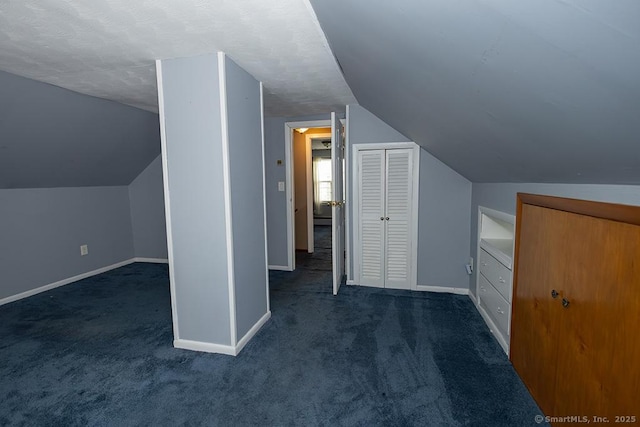 bonus room featuring baseboards, dark carpet, and vaulted ceiling