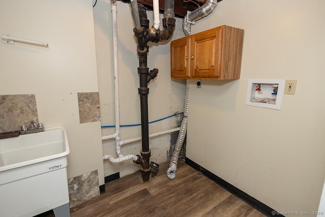 washroom with hookup for a washing machine, dark wood-type flooring, and cabinet space