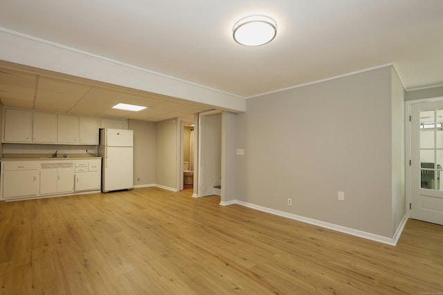 42 Wilridge Rd, Ridgefield, CT 06877 - unfurnished living room featuring crown molding, baseboards, light wood finished floors, and a sink