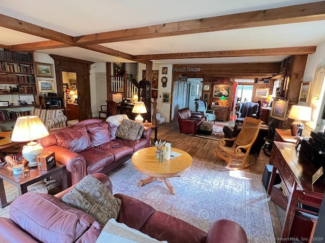 living room featuring stairs, beam ceiling, and wood finished floors