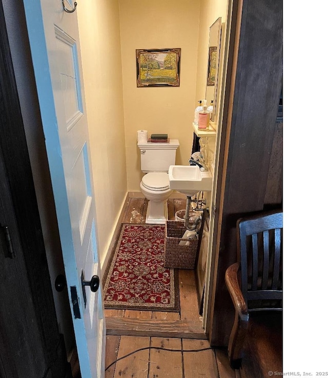 bathroom with toilet, tile patterned floors, and baseboards
