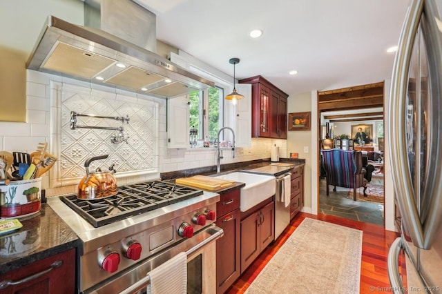 9 Columbus Ave, East Lyme, CT 06357 - kitchen featuring appliances with stainless steel finishes, wall chimney exhaust hood, a sink, dark brown cabinets, and decorative backsplash