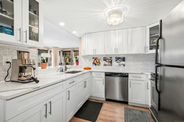 127 Greyrock Pl Unit 502, Stamford, CT 06901 - kitchen featuring appliances with stainless steel finishes, a sink, white cabinets, tasteful backsplash, and recessed lighting