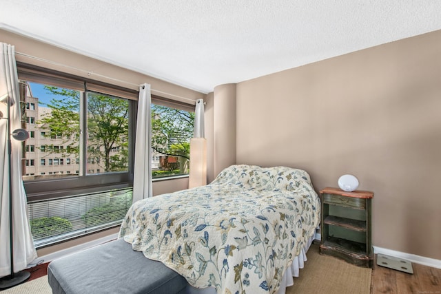 127 Greyrock Pl Unit 502, Stamford, CT 06901 - bedroom featuring multiple windows, baseboards, a textured ceiling, and wood finished floors