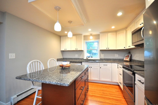 30 Taylor St, Windsor, CT 06095 - kitchen featuring stainless steel appliances, a baseboard heating unit, a kitchen breakfast bar, white cabinets, and recessed lighting