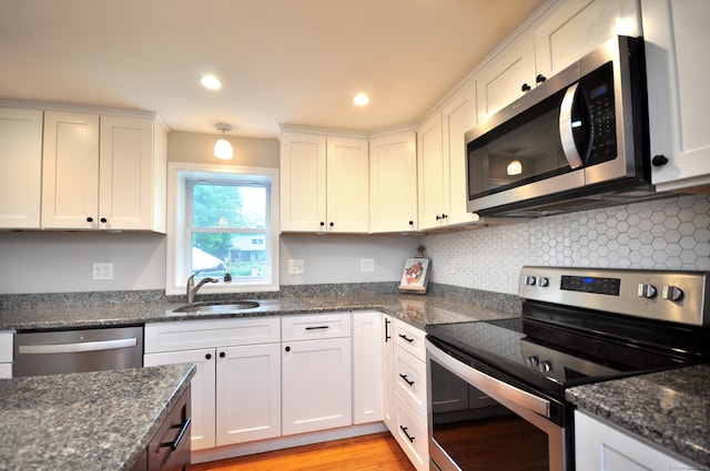 30 Taylor St, Windsor, CT 06095 - kitchen with appliances with stainless steel finishes, a sink, white cabinets, backsplash, and light wood-style floors