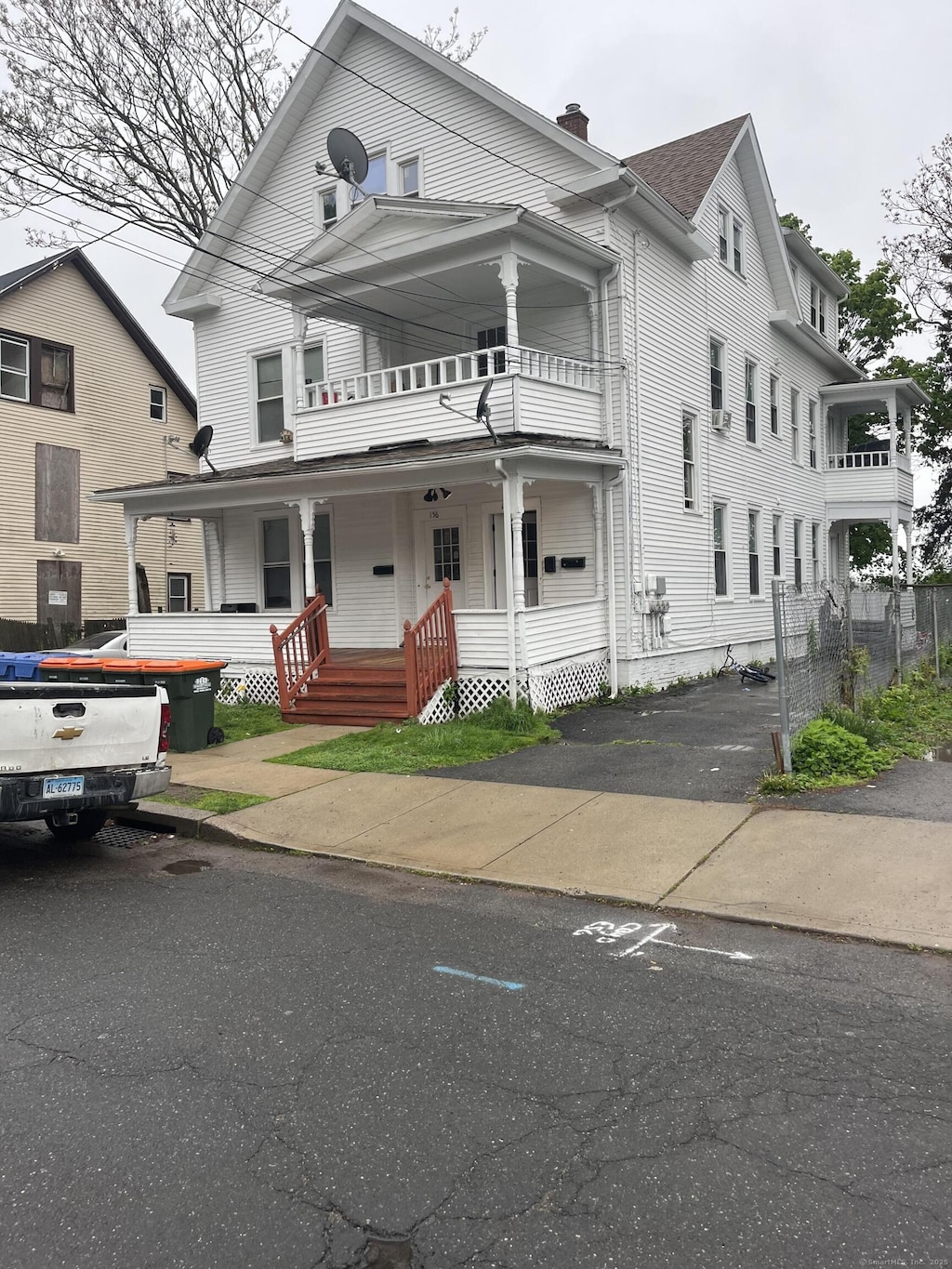 156 Hobart St, Meriden, CT 06450 - view of front of property featuring a balcony, covered porch, and a chimney