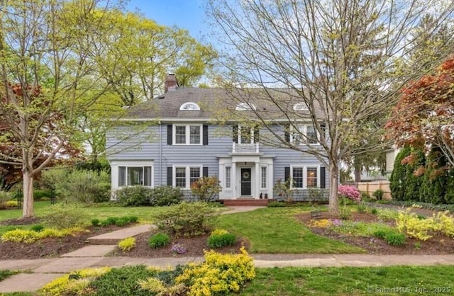 view of front of house with a front lawn and a chimney