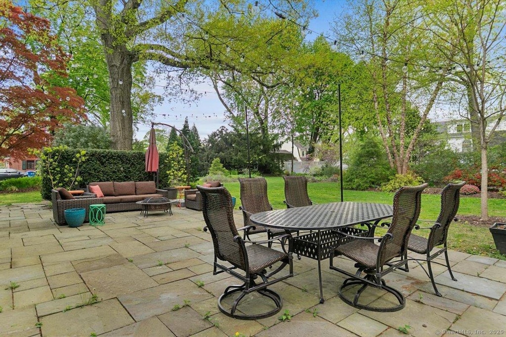 view of patio with outdoor dining space and an outdoor living space with a fire pit