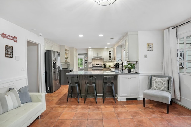 20 Fieldstone Dr, Easton, CT 06612 - kitchen featuring appliances with stainless steel finishes, a peninsula, a sink, under cabinet range hood, and backsplash