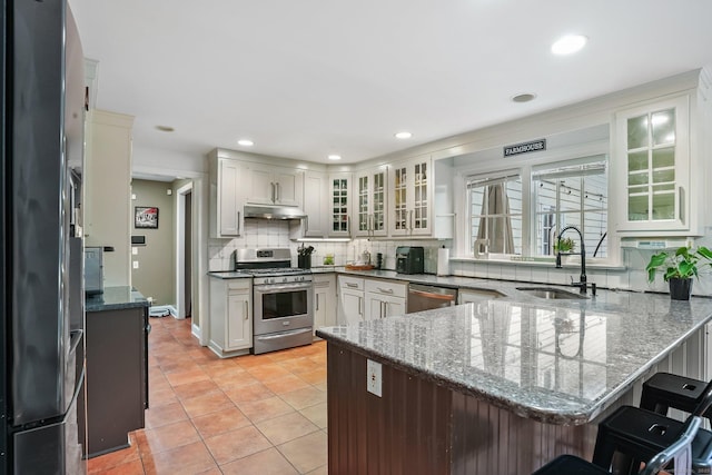 20 Fieldstone Dr, Easton, CT 06612 - kitchen with stainless steel appliances, a sink, a peninsula, under cabinet range hood, and tasteful backsplash
