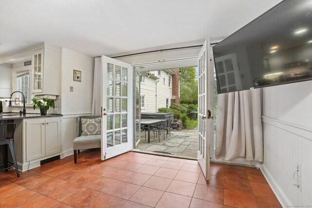 20 Fieldstone Dr, Easton, CT 06612 - doorway with french doors, light tile patterned floors, a decorative wall, wainscoting, and a sink