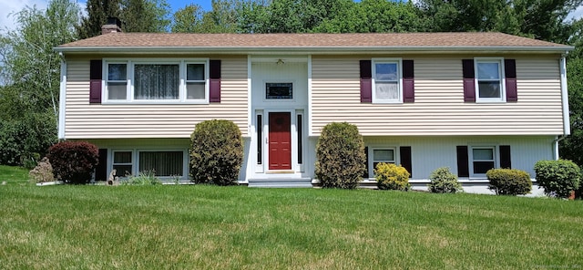 bi-level home featuring a chimney and a front yard
