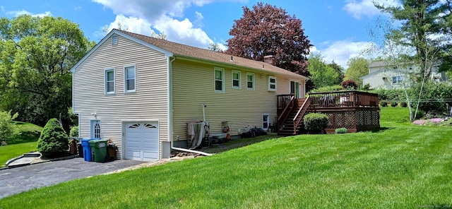 rear view of house with a wooden deck, stairs, a yard, an attached garage, and asphalt driveway