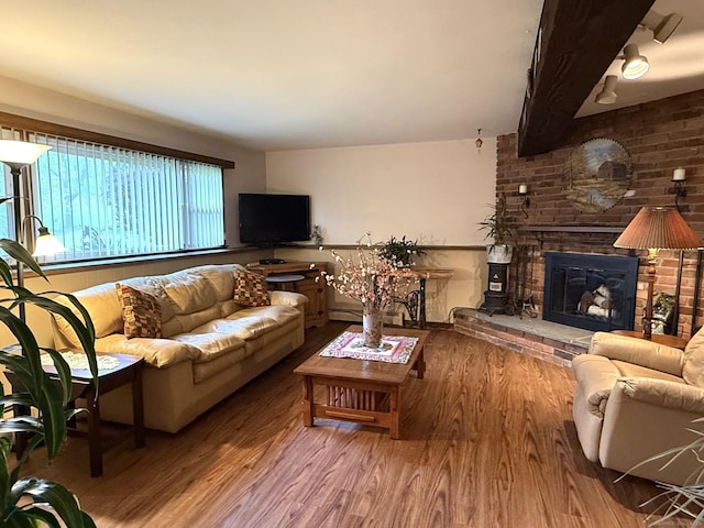 living room featuring wood finished floors and a brick fireplace