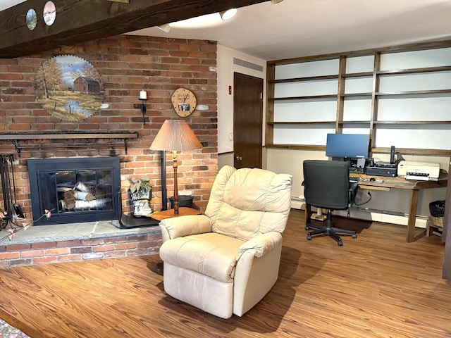 home office with wood finished floors, a brick fireplace, a baseboard radiator, and a baseboard heating unit
