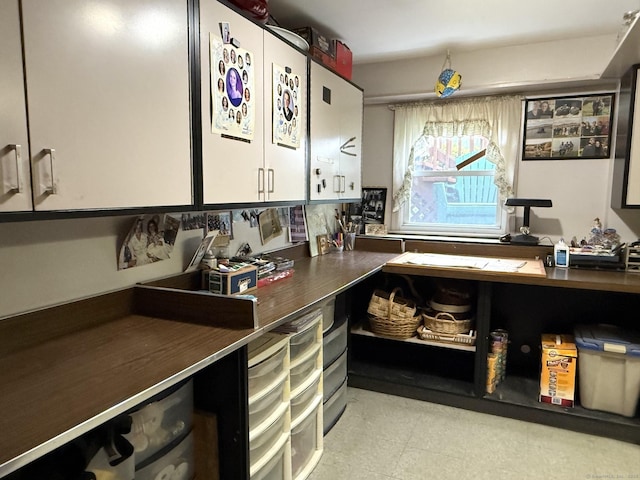 kitchen featuring dark countertops, white cabinets, and light floors