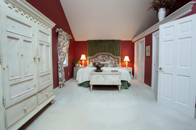 bedroom with lofted ceiling, carpet, and baseboards