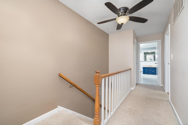 stairs with carpet floors, baseboards, and ceiling fan