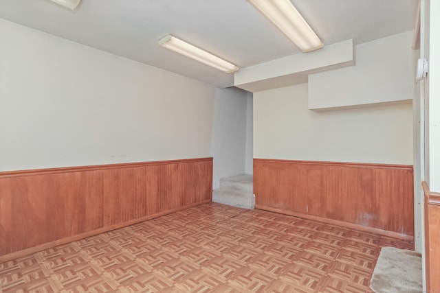 empty room featuring a wainscoted wall and wood walls