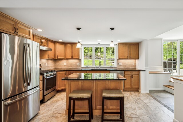 138 Flood Rd, Marlborough, CT 06447 - kitchen with stainless steel appliances, a sink, dark countertops, under cabinet range hood, and brown cabinetry