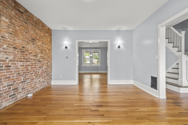669 Third Ave, West Haven, CT 06516 - spare room featuring brick wall, light wood finished floors, stairway, and baseboards